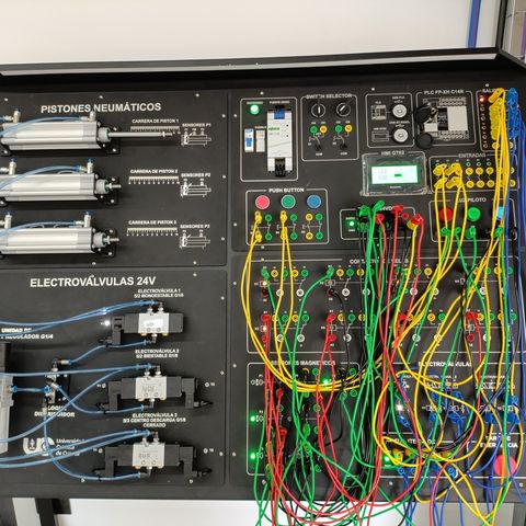 Banco didáctico SYSTRONIC de automatización industrial con PLC, pistones neumáticos y electroválvulas, completamente instalado y cableado